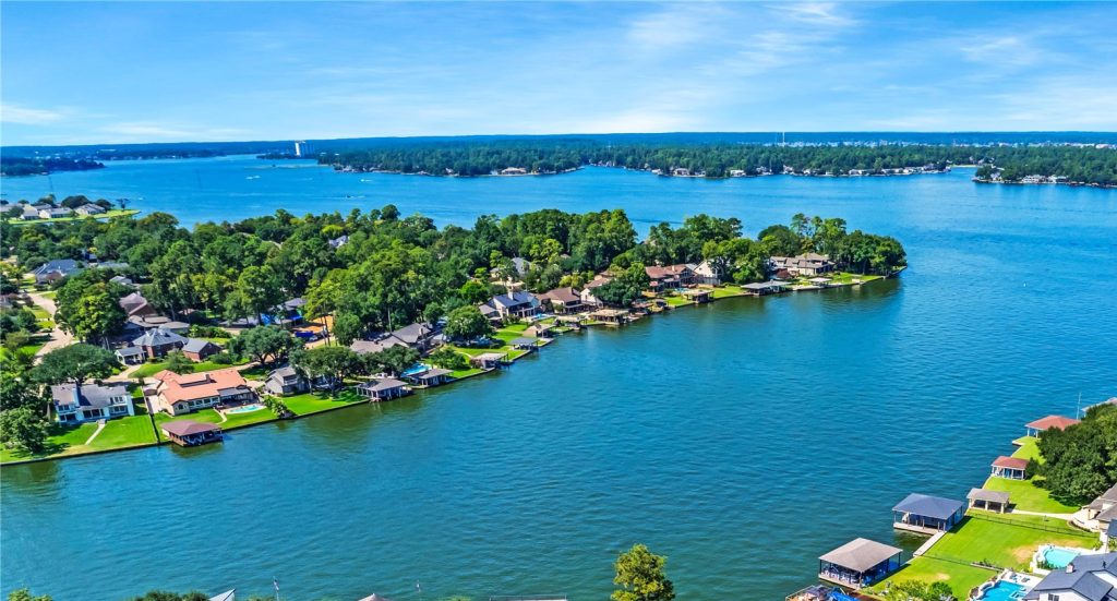 A vibrant drone shot of a Lake Conroe neighborhood along the water.