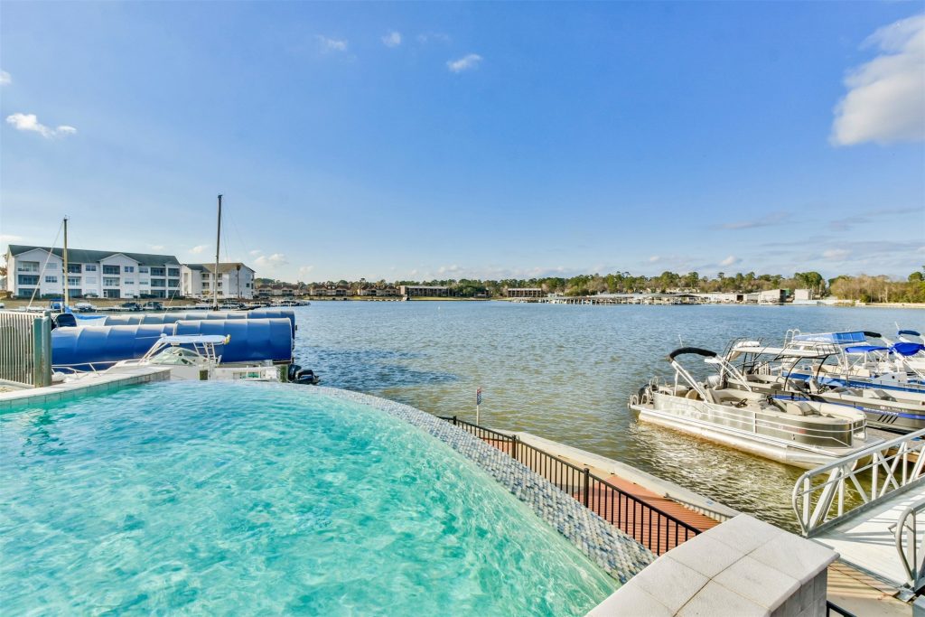 View of a luxury condo's pool area with the lake and docks in the background.
